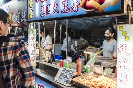 Kenting, Taiwan - February 24, 2018: Vendor prepares food at the Kenting main street night market located in Pingtung County.のeditorial素材