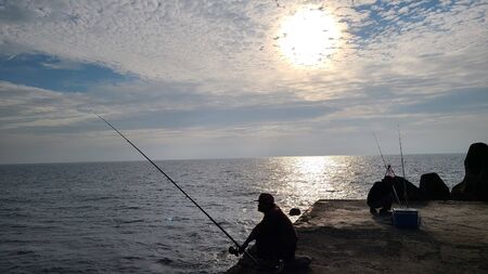 Silhouette of Fishing Flyfishing rod reel in river with golden sunlightの写真素材