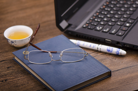 Stationery and laptop on a wooden tableのeditorial素材