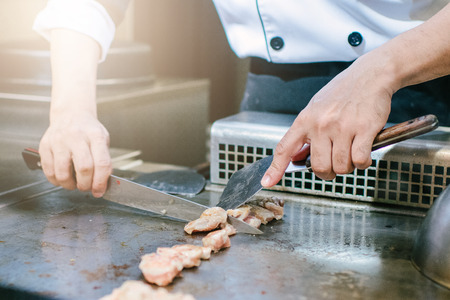 Hand of man take cooking of meat with vegetable grill, Chef cooking wagyu beef in Japanese teppanyaki restaurantの写真素材