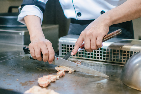 Hand of man take cooking of meat with vegetable grill, Chef cooking wagyu beef in Japanese teppanyaki restaurantの写真素材