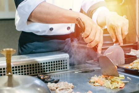 Hand of man take cooking of meat with vegetable grill, Chef cooking wagyu beef in Japanese teppanyaki restaurantの写真素材