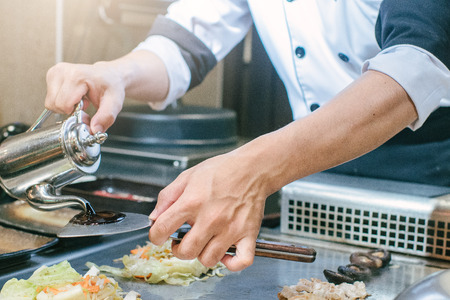 Hand of man take cooking of meat with vegetable grill, Chef cooking wagyu beef in Japanese teppanyaki restaurantの写真素材