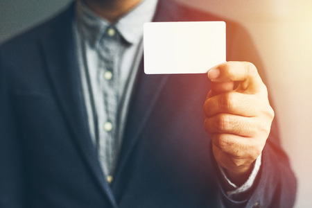 Man holding white business card,Man wearing blue shirt and showing blank white business card. Blurred background. Horizontal mockup, Smart asian business Person Professional Occupation cheerfulの写真素材