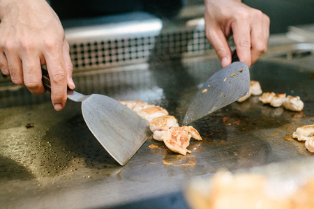 Hand of man take cooking of meat with vegetable grill, Chef cooking wagyu beef in Japanese teppanyaki restaurantの写真素材