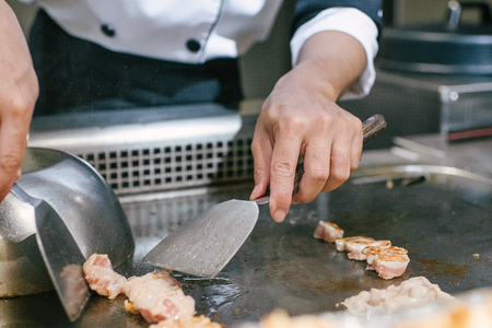 Hand of man take cooking of meat with vegetable grill, Chef cooking wagyu beef in Japanese teppanyaki restaurantの写真素材