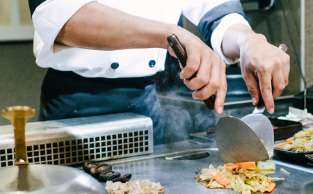 Hand of man take cooking of meat with vegetable grill, Chef cooking wagyu beef in Japanese teppanyaki restaurantの写真素材