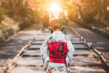 Young women wearing traditional Japanese Kimono  with colorful maple trees in autumn is famous in autumn color leaves and cherry blossom in spring, Kyoto, Japan.の写真素材