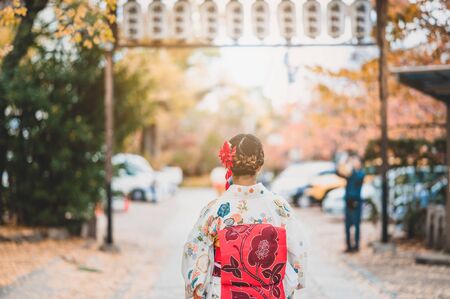 Young women wearing traditional Japanese Kimono  with colorful maple trees in autumn is famous in autumn color leaves and cherry blossom in spring, Kyoto, Japan.の写真素材
