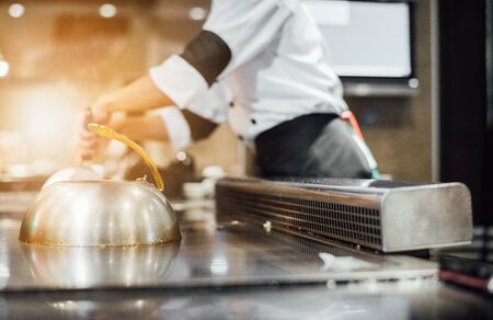 Hand of man take cooking of meat with vegetable grill, Chef cooking wagyu beef in Japanese teppanyaki restaurantの写真素材