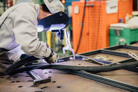Industrial worker in manufacturing plant grinding to finish a Metal pipe,Industrial Worker at the...