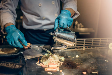 Hand of man take cooking of meat with vegetable grill, Chef cooking wagyu beef in Japanese teppanyaki restaurantの写真素材