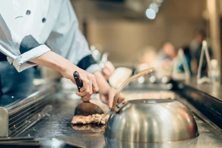 Hand of man take cooking of meat with vegetable grill, Chef cooking wagyu beef in Japanese teppanyaki restaurantの写真素材