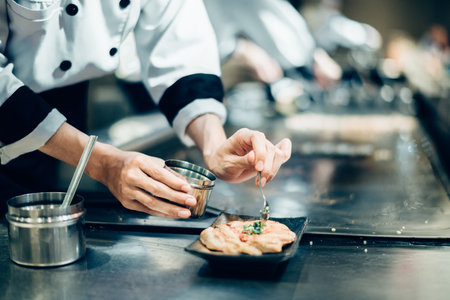 Hand of man take cooking of meat with vegetable grill, Chef cooking wagyu beef in Japanese teppanyaki restaurantの写真素材