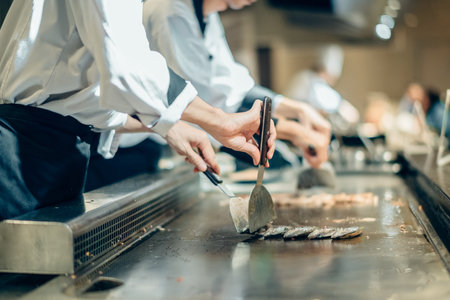Hand of man take cooking of meat with vegetable grill, Chef cooking wagyu beef in Japanese teppanyaki restaurantの写真素材