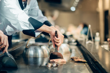 Hand of man take cooking of meat with vegetable grill, Chef cooking wagyu beef in Japanese teppanyaki restaurantの写真素材