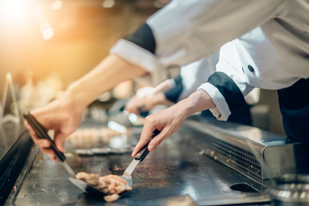 Hand of man take cooking of meat with vegetable grill, Chef cooking wagyu beef in Japanese teppanyaki restaurantの写真素材