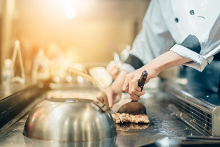 Hand of man take cooking of meat with vegetable grill, Chef cooking wagyu beef in Japanese teppanyaki restaurantの写真素材