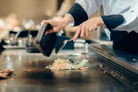 Hand of man take cooking of meat with vegetable grill, Chef cooking wagyu beef in Japanese teppanyaki restaurantの写真素材