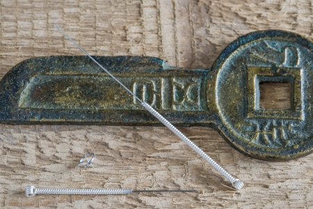 Acupuncture needles with antique chinese coinの写真素材