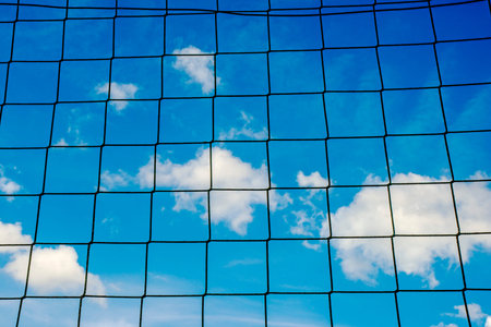 football goal net with blue sky and cloudsの写真素材