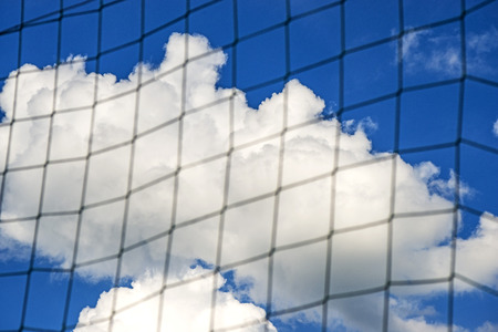 football goal net with blue sky and cloudsの写真素材