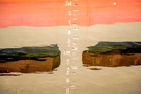 Marking the draft reflected in the harbor waterの写真素材