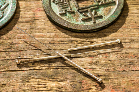 Acupuncture needles with antique chinese coinの写真素材