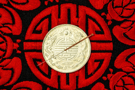 acupuncture needle on Chinese coin and symbol for immortalityの写真素材