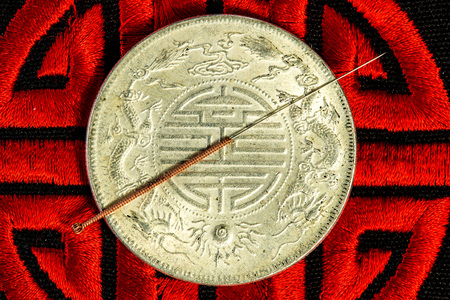 acupuncture needle on Chinese coin and symbol for immortalityの写真素材
