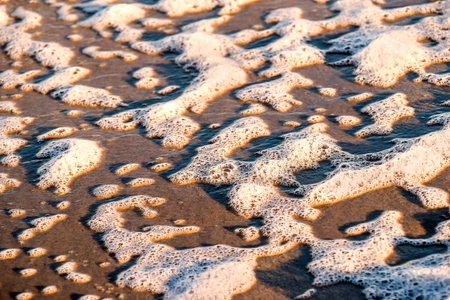 sandy beach with spray of the surfの写真素材
