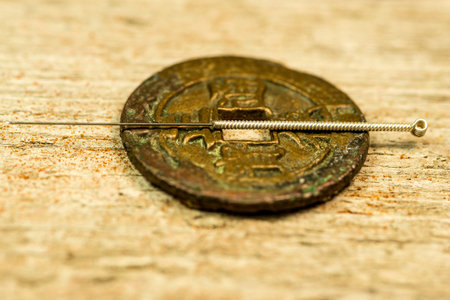 acupuncture needle on antique Chinese coinの写真素材