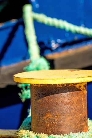 bollard with mooring line and blue ship hullの写真素材