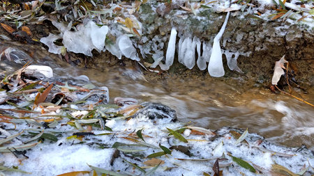 little creek in winter with iciclesの写真素材