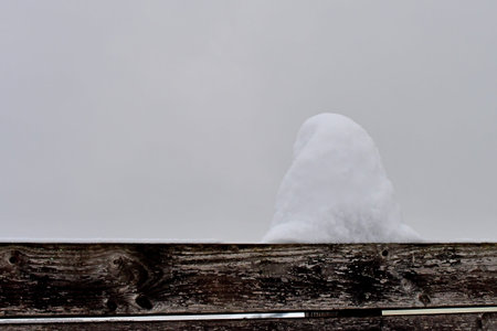 winter scene with snow hood on wooden fenceの写真素材