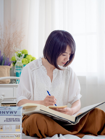 Beautiful woman reading a book in morningの写真素材