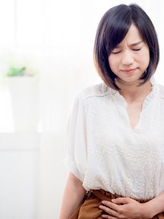Young asian woman with stomachacheの写真素材