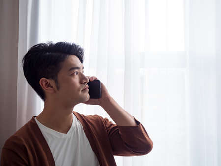 Young man wearing casual clothes talking on a mobile phoneの写真素材
