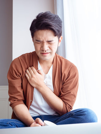Young asian man having heart attack