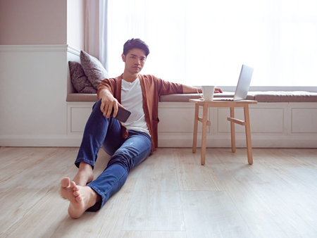 Young man wearing casual clothes and holding mobile phone