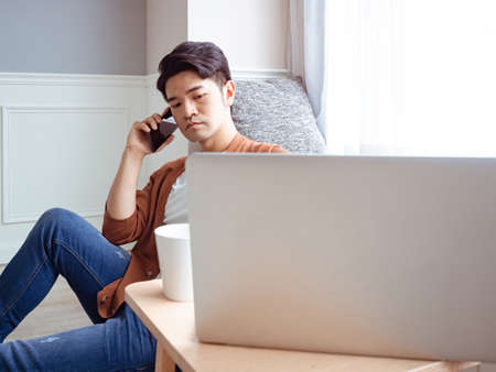 Young man wearing casual clothes and talking on mobile phoneの写真素材