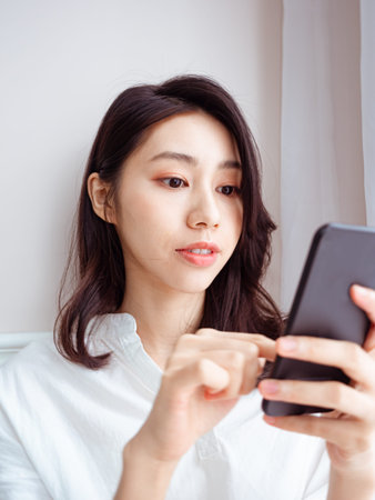 Young asian woman using smartphone at home