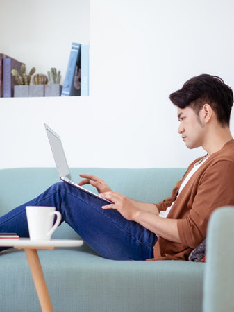 Young man wearing casual clothes and using laptopの写真素材