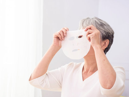 closeup senior asian woman's face and facial maskの写真素材