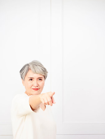 Senior asian woman pointing up 1 finger.の写真素材