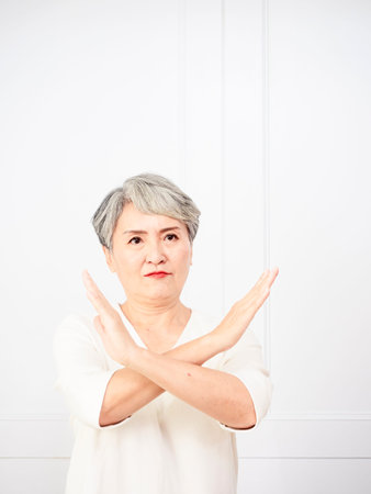 Senior beautiful grey-haired woman wearing casual dress doing stop sign with palm of the hand. Warning expression with negative and serious gesture on the face.の写真素材
