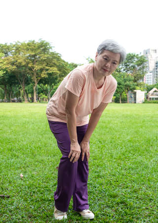 Portrait of mature asian woman 60s having the joint pain at park outdoor.の写真素材