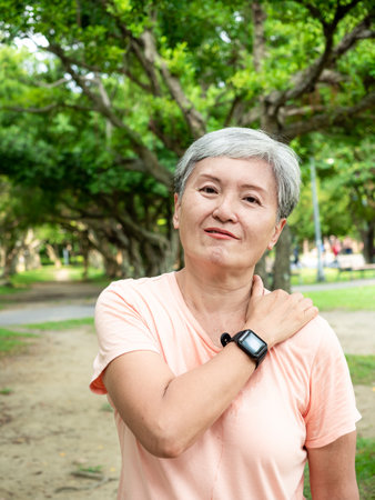 Portrait of mature asian woman 60s with knee pain at park outdoor.の写真素材