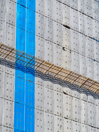 Building under construction wrapped blue and white protection safety net.