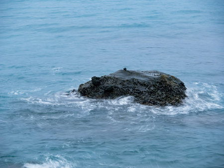Sea waves impact rock on the beach